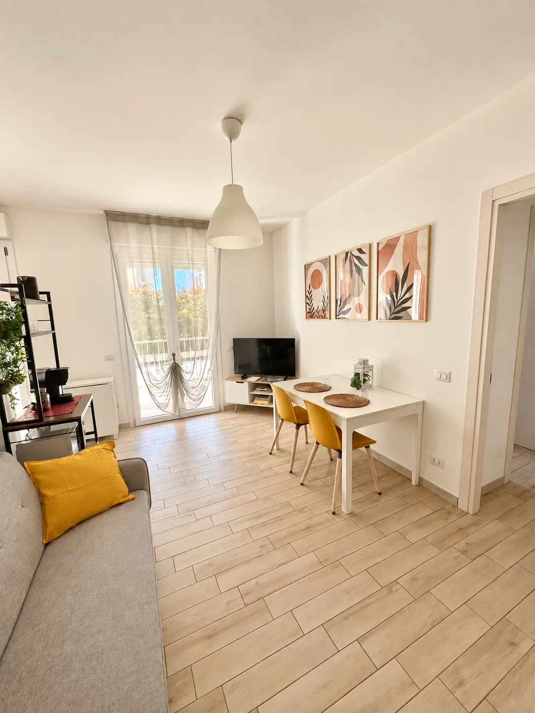 Panoramica della zona giorno con tavolo e accesso alla veranda