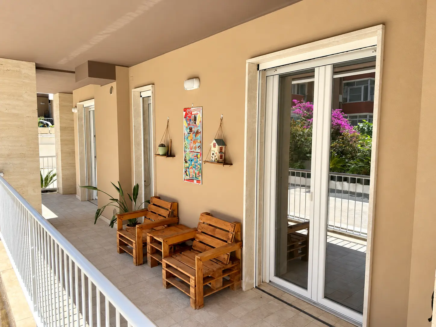 Veranda esterna arredata con sedute in legno davanti alla casa